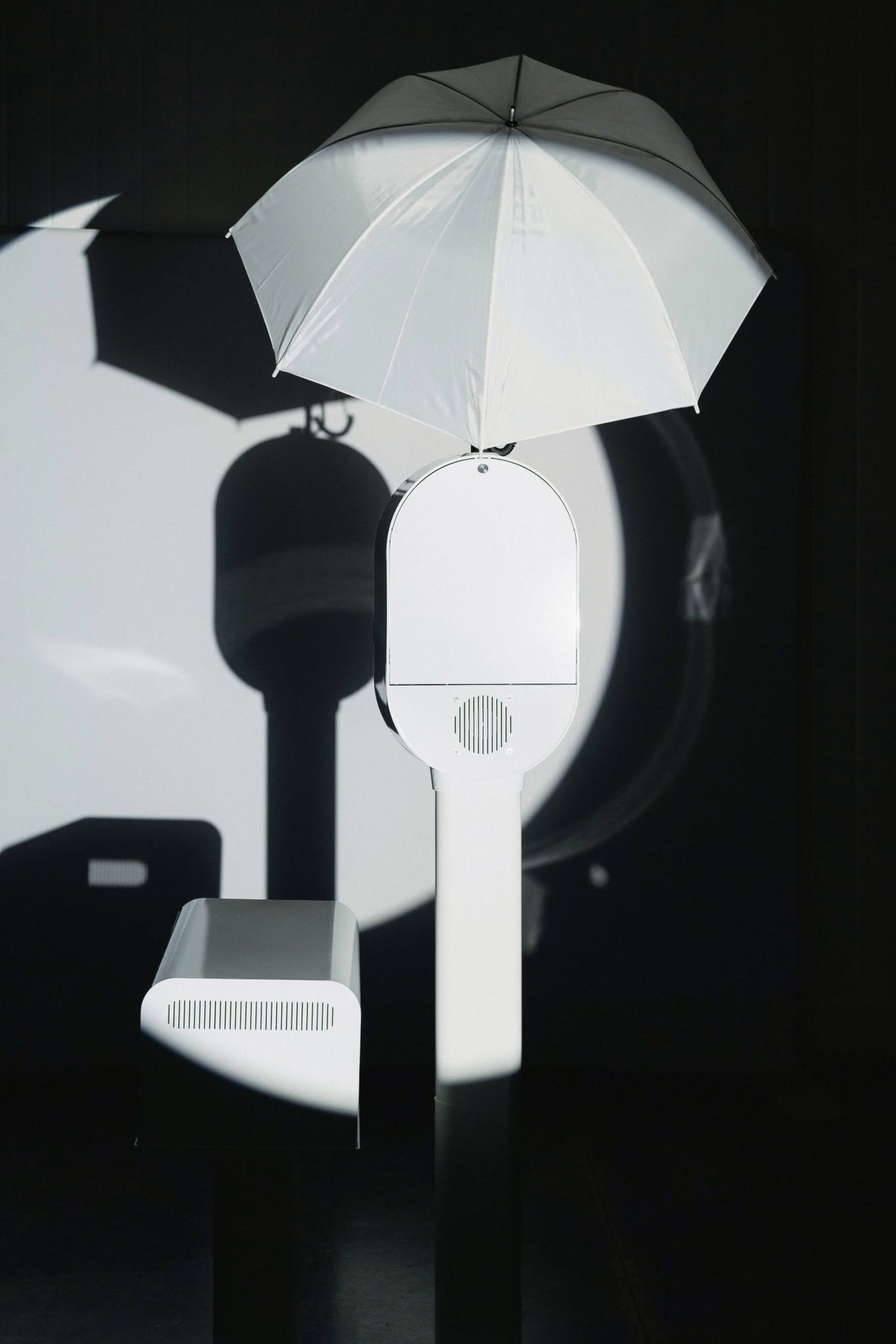 The white photo booth under its umbrella light.