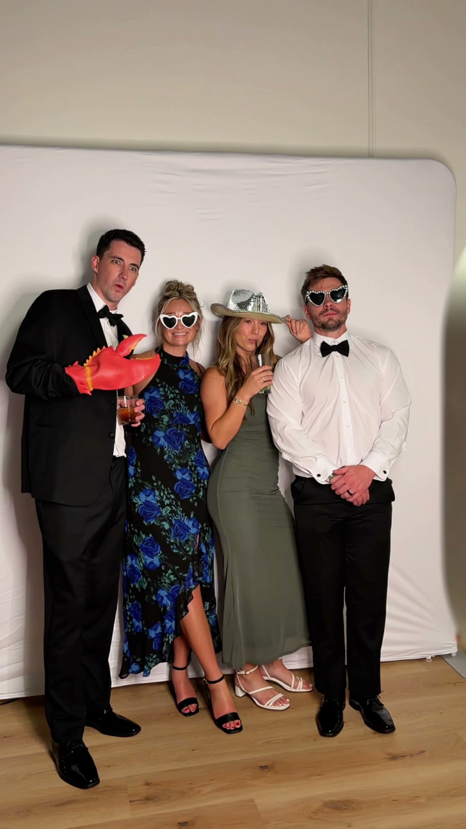 Four guests with a lobster claw, a disco cowboy hat and heart sunglasses at a white backdrop.
