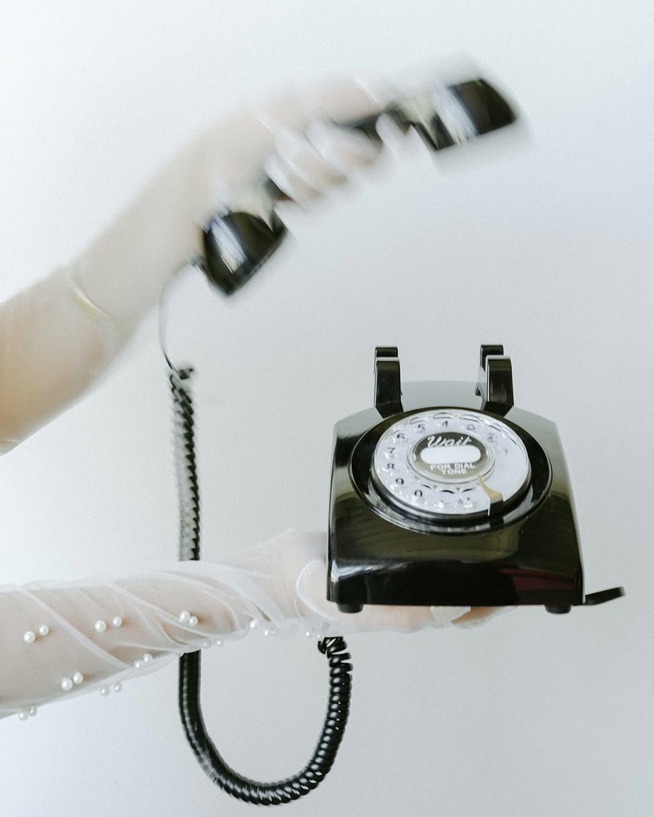 Gloved hands holding the retro telephone used for the audio guestbook.